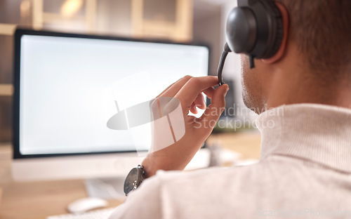 Image of Call center, man and computer screen in office for customer service, sales or evening support. Male agent, consultant or headset microphone for telemarketing, telecom or crm help mockup on technology
