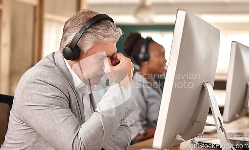 Image of Call center, man and stress burnout at computer in office and tired of sales or customer service. Mature male, agent and consultant in telemarketing headache, support and crm mental health problem