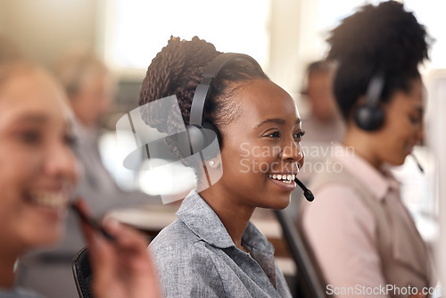 Image of Call center, black woman and smile on face for sales, telemarketing and support. Professional female consultant or agent with a headset, mic and team for customer service, crm or help desk for advice