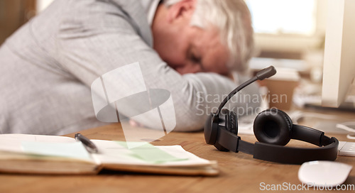 Image of Call center, sleeping and tired man by headset in office with burnout of sales and customer service. Mature agent or consultant in telemarketing, support and crm with mental health or fatigue problem