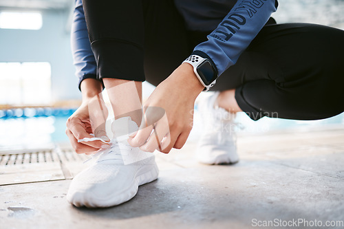 Image of Tie shoes, hands and fitness at swimming pool to start workout, exercise or training. Sports, athlete and woman tying sneakers to get ready for swim, practice or exercising for health and wellness.