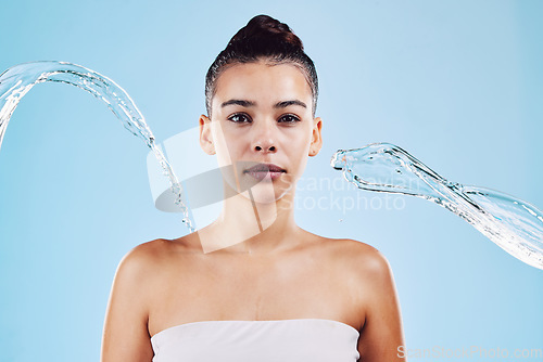 Image of Portrait, skincare and woman with water, beauty and grooming against a blue studio background. Face cleaning, female and person with clear liquid, aqua and cosmetics for morning routine and hygiene