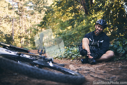 Image of Sports man, injury and bicycle outdoor while cycling on mountain bike in nature with leg pain. Athlete person on ground in forest for fitness exercise, training or workout accident crash or fall