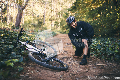 Image of Sports man, injury and leg pain outdoor while cycling on mountain bike with nature trees and dirt. Athlete person on ground in forest for fitness exercise, training or workout accident, crash or fall