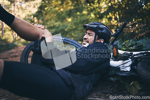 Image of Man, cycling injury and leg or knee pain outdoor on mountain bike in nature. Athlete person on forest ground for fitness exercise or training workout accident, crash or fall with helmet and bicycle