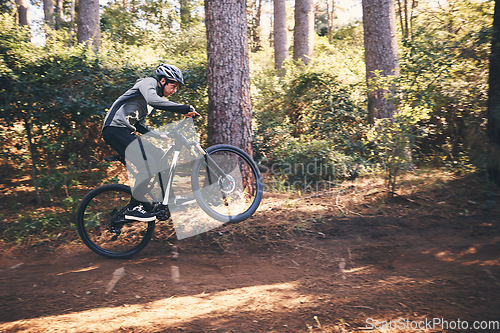 Image of Cycling, nature and cardio with man on path for training, workout or fitness exercise. Adventure, extreme sports and speed with male cyclist on bike in forest park for performance, challenge or break