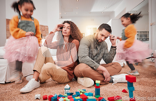 Image of Family, girl playing and parents with stress, frustrated or in living room with a headache or burnout. Mother, father or female child with toys, busy or fast speed in lounge, home or hyper active kid