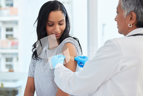 Image of Healthcare, woman and doctor with plaster, vaccination and consultation in a hospital, cure and disease. Female patient, client and medical professional with care, vaccine and injection for safety