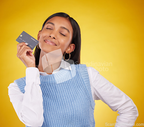 Image of Credit card, smile and Indian woman on yellow background for bank, investment and payment in studio. Banking mockup, finance and happy girl with plastic for budget, commerce and promotion purchase