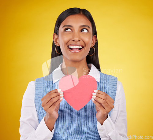 Image of Smile, paper and heart with woman in studio for love, support and romance. Valentines day, kindness and date with female and holding symbol on yellow background for health, happiness and hope mockup