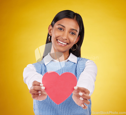 Image of Giving, paper and heart with portrait of woman in studio for love, support and romance. Valentines day, kindness and date with female and symbol on yellow background for health, happiness and hope