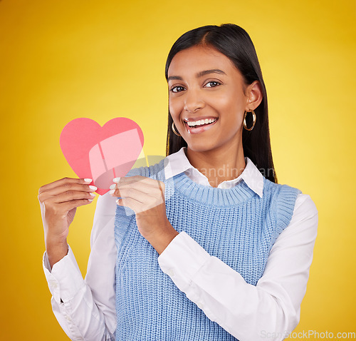 Image of Happy, paper and heart with portrait of woman in studio for love, support and romance. Valentines day, kindness and date with female and symbol on yellow background for health, happiness and hope