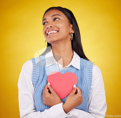 Image of Love, paper and heart with woman in studio for happy, support and romance. Valentines day, kindness and date with female and holding symbol on yellow background for health, happiness and hope mockup