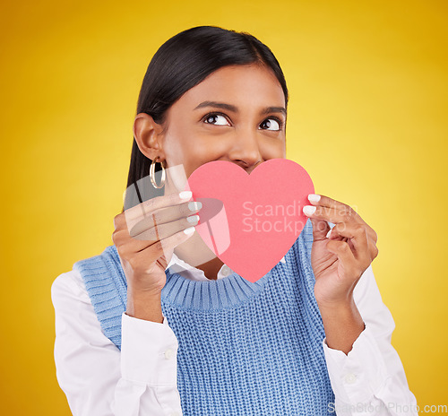 Image of Shy, paper and heart with woman in studio for love, support and romance. Valentines day, kindness and date with female and hiding with symbol on yellow background for health, happiness or hope mockup