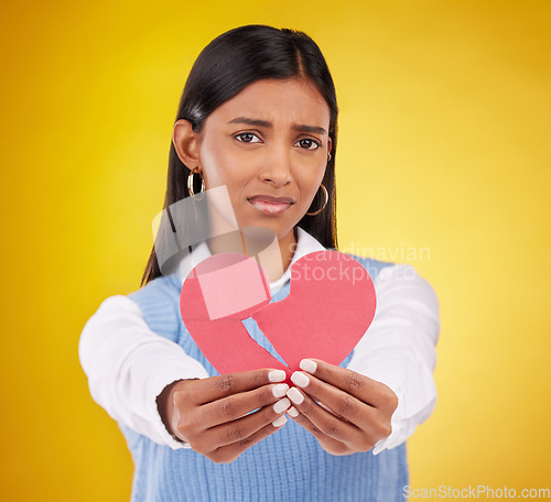 Image of Heartbreak, sad and woman in a studio with paper icon and emoji from break up. Depressed, isolated and yellow background of a person portrait feeling unhappy, grief and disappointed from love loss