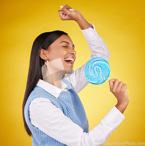 Image of Candy, sing and woman with lollipop, happy and cheerful against a studio background. Female, excited and girl with sweets, dessert and happiness with treat, freedom and wellness with joy and positive