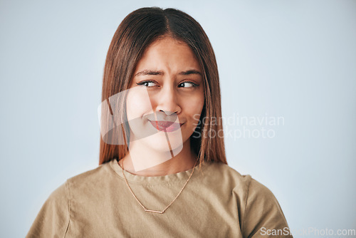 Image of Thinking, doubt and question with a woman on a gray background in studio looking for an answer. Idea, confused and opinion with an attractive young female feeling thoughtful while contemplating