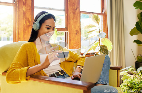 Image of Happy woman, laptop and credit card with ecommerce and headphones to listen to music while online shopping. Female relax at home, radio streaming with fintech, internet banking and payment success