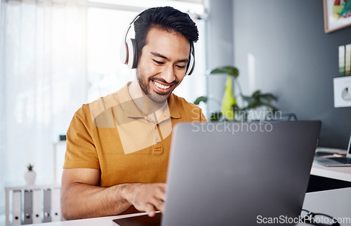 Image of Man is working from home, laptop and headphones while listening to music, happy and busy at desk. Male copywriter typing, freelance and blogger with remote work, technology and online audio streaming