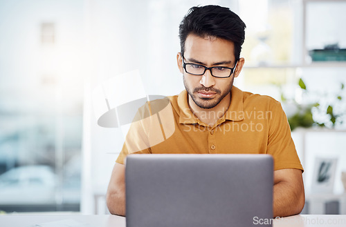 Image of Serious, work and an Asian man with a laptop in a home office for communication, email and internet. Business, research and an entrepreneur or freelance worker typing a proposal on a computer