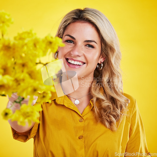 Image of Portrait, smile and woman showing flowers in studio isolated on a yellow background. Floral, bouquet present and happiness of person or female model sharing natural plants and fresh flower for spring