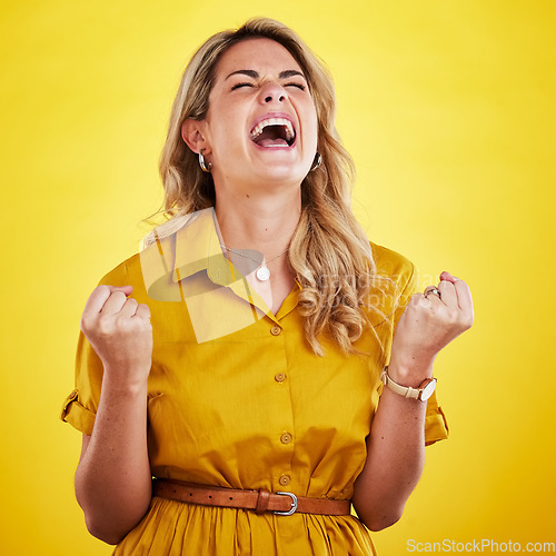 Image of Woman, fist celebration and shout in studio for winning, goals or success with happiness by yellow background. Girl, happy and winner with crazy screaming for bonus, profit or prize from competition