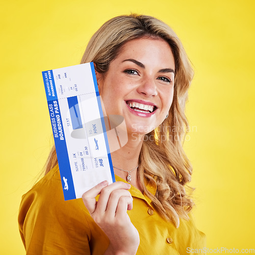 Image of Happy woman, plane ticket and smile for travel, flight or vacation against a yellow studio background. Portrait of female traveler smiling with boarding pass, passport or permit for traveling or trip