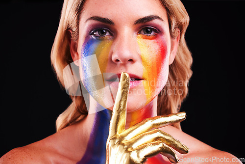 Image of Woman, metallic portrait and beauty secret with color paint cosmetics on skin and face in studio. Female model on a black background for gold art, fantasy and creative makeup with finger on lips