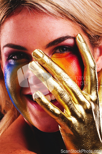 Image of Gold hand, woman and beauty portrait with color paint cosmetics on skin and face in studio. Female model person with a happy smile for art deco, fantasy and creative makeup with metallic shine