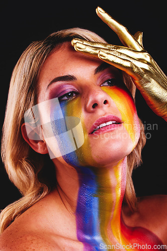 Image of Woman, beauty face and gold color paint and cosmetics on skin in studio. Female model person on a black background for art deco, fantasy and creative rainbow makeup with metallic hand on head