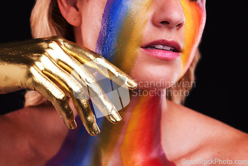 Image of Woman, gold hand and beauty with color, paint or cosmetics on skin and face in studio. Female model person on a black background for art deco, fantasy and creative rainbow makeup or metallic closeup