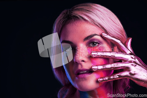 Image of Woman, metallic hand and beauty portrait with color paint cosmetics on skin and face in studio. Female model person on a black background for art deco, fantasy and creative makeup with a neon light