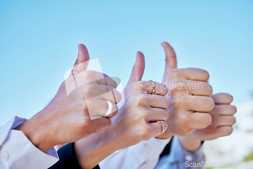 Image of Business people, hands and thumbs up in agreement, thank you or good job for teamwork in the outdoors. Hand of group showing thumb emoji, yes sign or like for team success, ok or approval on blue sky