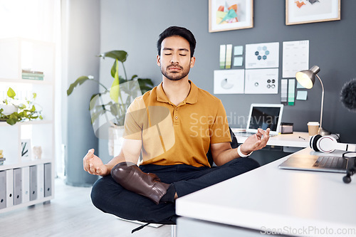Image of Yoga, office and business man in lotus pose for mental health and breathing exercise at a desk. Corporate, meditation and asian guy manager meditating for stress management, zen and peace in Japan