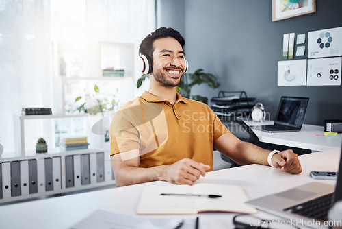 Image of Business man, smile and thinking with headphones while listening to music, audio or podcast in office. Asian male entrepreneur at desk while excited for idea, plan or goals at a modern workplace