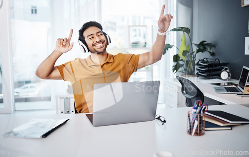 Image of Business man, dancing and laptop with headphones to listen to music or celebrate success. Happy asian male entrepreneur at desk with a smile and hands for achievement, victory dance or goals