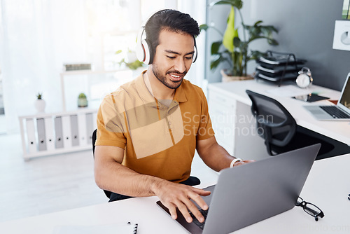 Image of Laptop, headphones and business man listening to music, audio and working. Asian male entrepreneur at desk to listen to a song while typing for online research, email or social media with internet