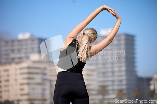 Image of Rear view, woman and stretching arms outdoors for training, running and morning cardio routine. Back, warm up and stretch before fitness, exercise and sports workout, wellness and performance