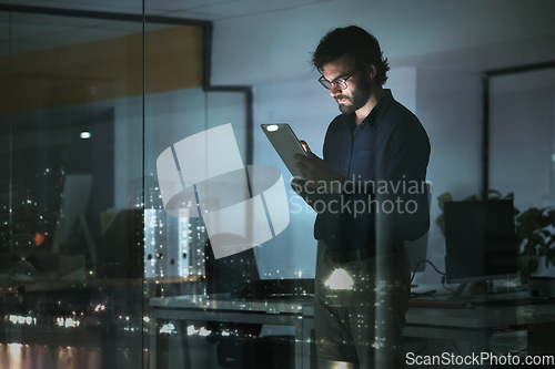 Image of Night, news or businessman with tablet in office to search digital technology, data analytics or global media. City view, entrepreneur or focused person typing on iot dashboard or networking online