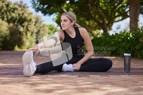 Image of Thinking, stretching and a woman in a park for running, fitness preparation and morning cardio. Serious, sports and an athlete runner with a warm up on the ground before exercise training in nature