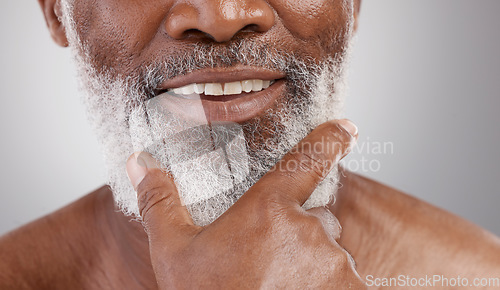 Image of Beauty, hand and beard with a senior man in studio on a gray background for skincare or grooming. Mouth, smile and facial hair with a happy mature male closeup for a luxury cosmetic facial product
