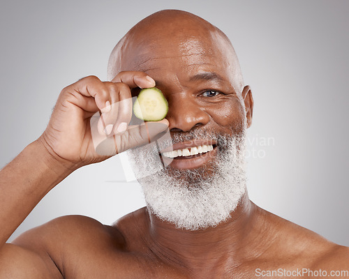 Image of Senior black man, portrait smile and cucumber for natural skincare, nutrition or health against a gray studio background. Happy African American male with vegetable for healthy skin, diet or wellness