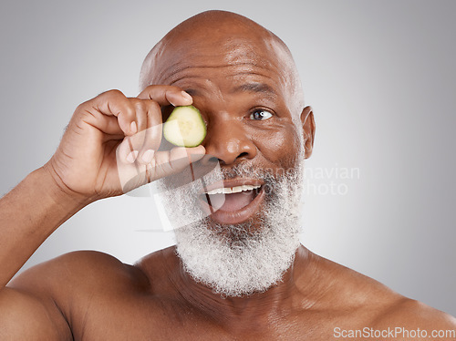 Image of Senior black man, smile and cucumber for skincare, natural nutrition or health against a gray studio background. Happy African American male with vegetable citrus for healthy skin, diet or wellness