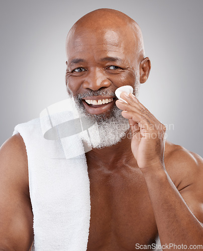 Image of Dermatology, cotton pad and portrait of black man with smile, happiness and anti ageing treatment in studio backdrop. Skin care, cosmetic and happy, mature model with morning skincare or face routine
