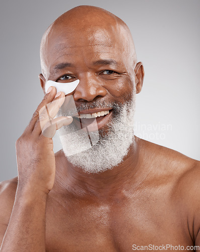 Image of Skincare, eye pad or portrait of man with smile, happiness and anti ageing face treatment. Dermatology, cosmetic grooming or happy, mature and African model or collagen eyes mask on white background