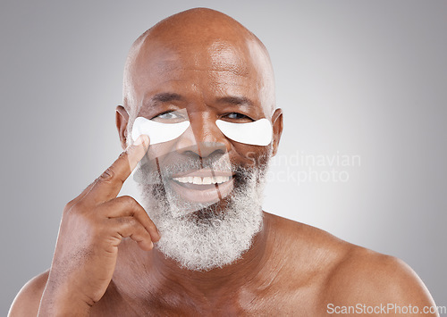 Image of Collagen eye mask, skincare or portrait of black man and smile, happiness or face treatment on white background Dermatology, cosmetic facial and happy, mature or model and eyes pad on studio backdrop