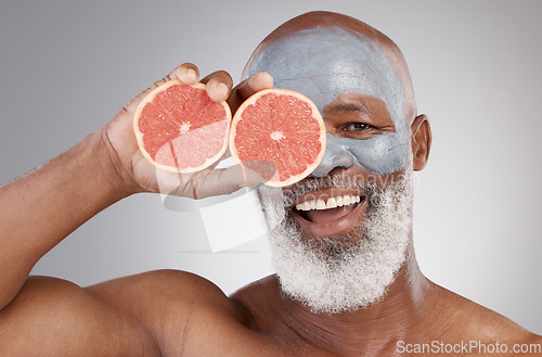 Image of Senior black man, grapefruit and smile in skincare, vitamin C or natural nutrition against gray studio background. Portrait of happy African male with fruit and face mask for healthy skin or wellness