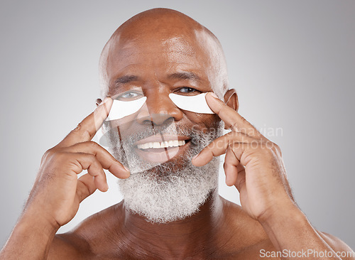 Image of Dermatology, eye pads on face and portrait of black man with smile, happiness and anti ageing collagen spa treatment. Skincare, cosmetic process and happy, mature model in morning skin care routine.