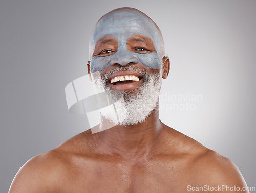 Image of Skincare, clay mask and portrait of black man with smile, happiness and anti ageing treatment on studio background. Dermatology, cosmetic grooming and happy, mature model in charcoal skin care facial