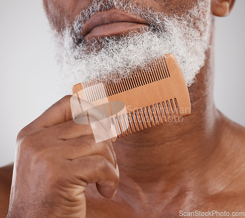 Image of Man, hands and comb on beard for grooming, beauty or skincare hygiene against a studio background. Closeup of senior male neck and chin combing or brushing facial hair for clean wellness or haircare